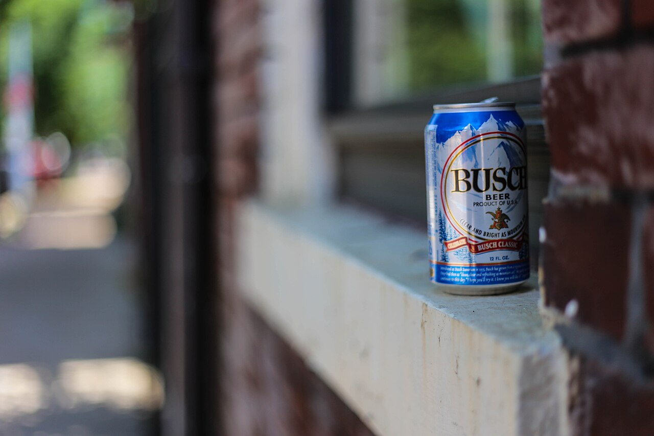 Busch Beer can with its snowy mountain label on a brick window ledge, shallow depth of field